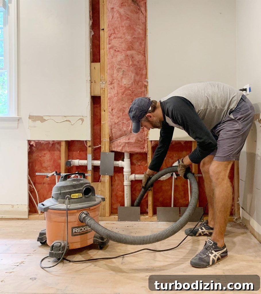 Managing Renovation Stress: 5 Practical Tips for a Smoother Remodel 14 John Using Shop Vac To Remove Dust During Bathroom Renovation