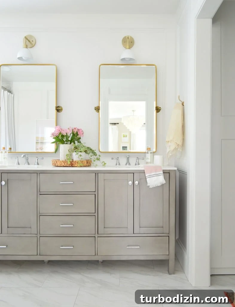 Bathroom Makeover Before and After Photos + Exact Cost Breakdown 6 Traditional Gray Double Vanity In Bathroom With Brass Pivot Mirrors And Shades Of Light Dapper Sconce