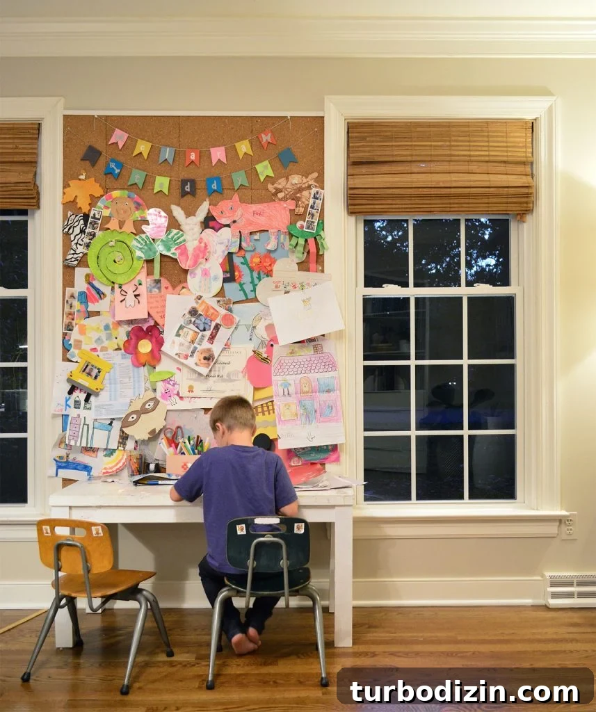 Son Working At Small Art Desk Space In Preschool Chairs With Large Corkboard Display Space Between Windows