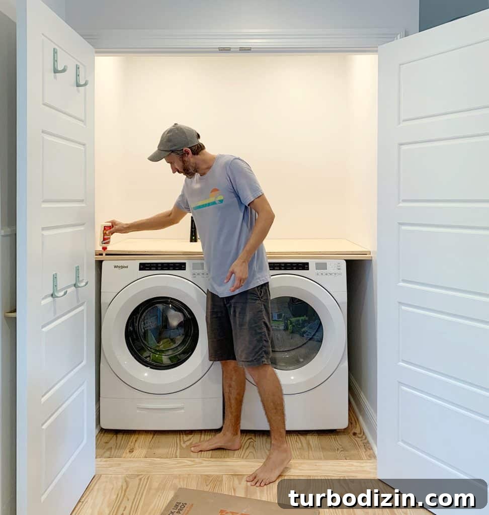 Man adding wood glue to front of laundry closet plywood counter