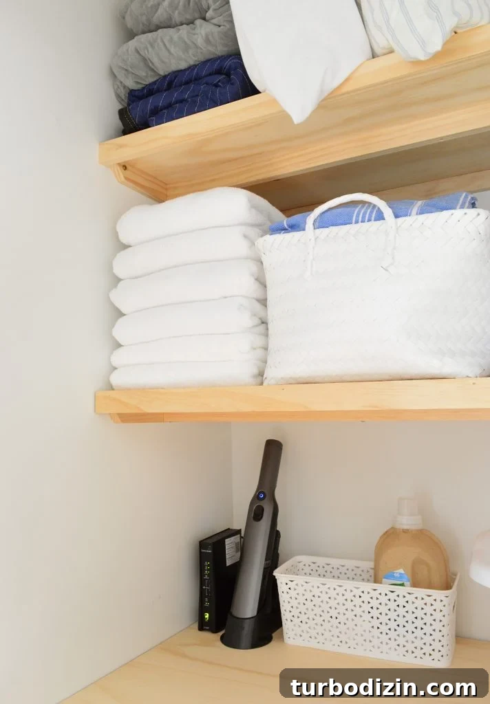 Towels and baskets stored on wood laundry shelves with support braces underneath