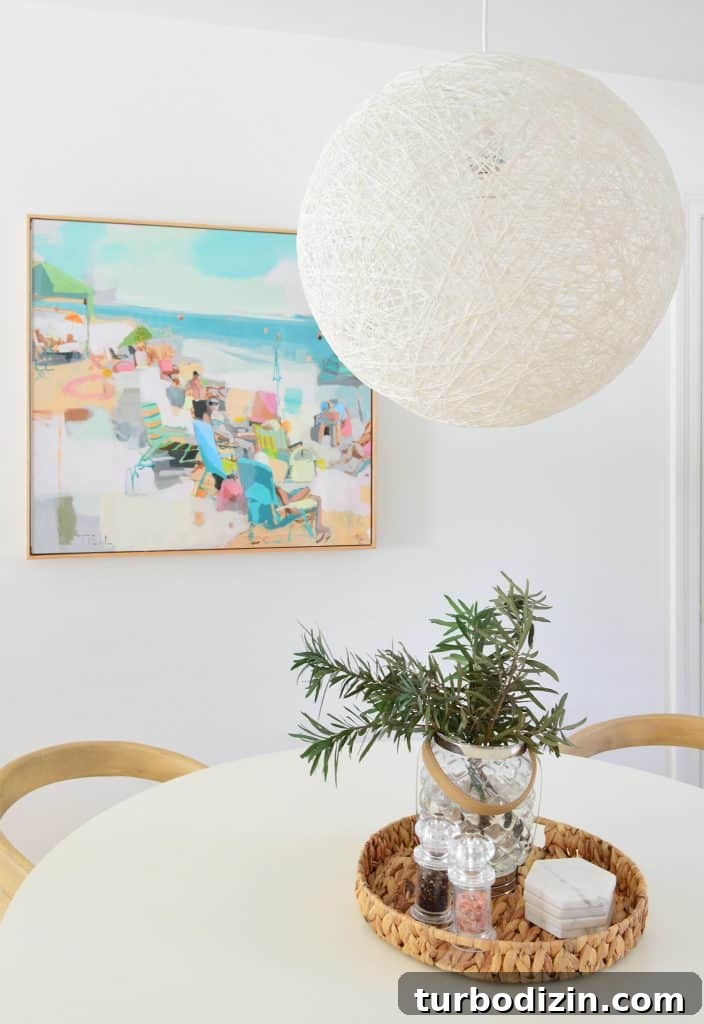 5 Quick Kitchen Updates to Transform Your Space 13 Large String Globe Pendant Light Over White Table With Beachy Art In Background