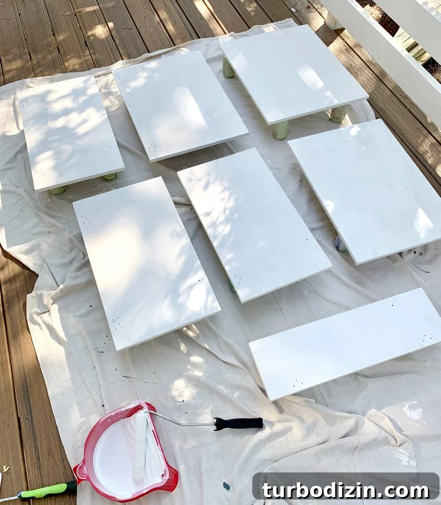 How We Painted Our Kitchen Cabinets Pink: A Room-by-Room Reveal 13 Cabinet doors laid on drop cloth with coat of white primer drying