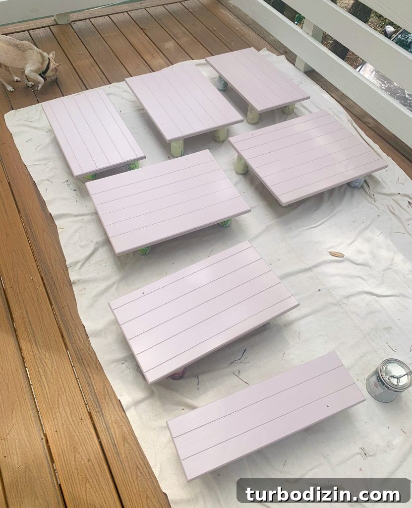 How We Painted Our Kitchen Cabinets Pink: A Room-by-Room Reveal 14 Wood cabinet doors on drop cloth drying with coat of mauve paint