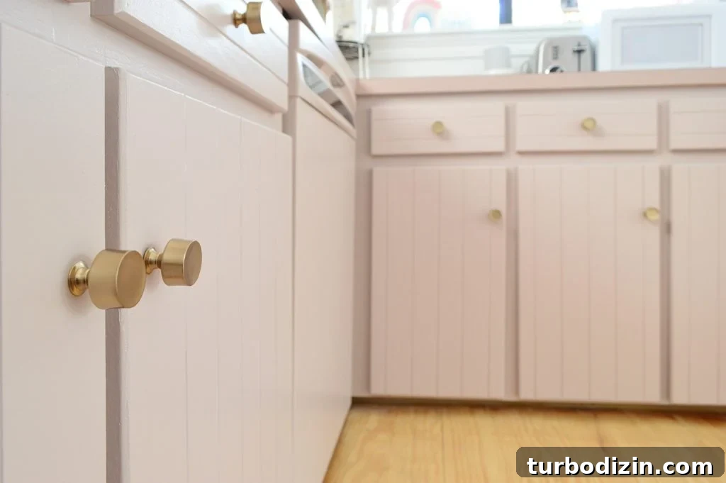 How We Painted Our Kitchen Cabinets Pink: A Room-by-Room Reveal 18 Close up after photo of mauve cabinets with brass gold hardware knobs