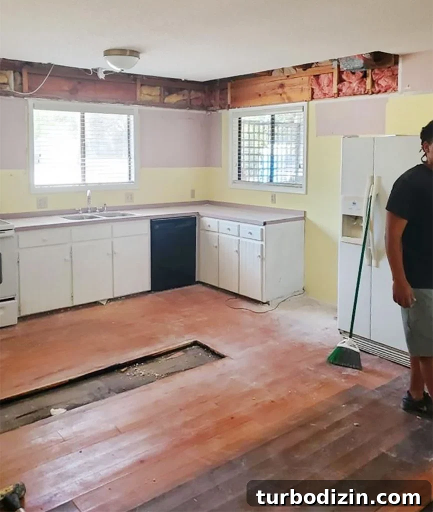 How We Painted Our Kitchen Cabinets Pink: A Room-by-Room Reveal 8 Photo of kitchen renovation mid demolition with mauve wall paint behind cabinets