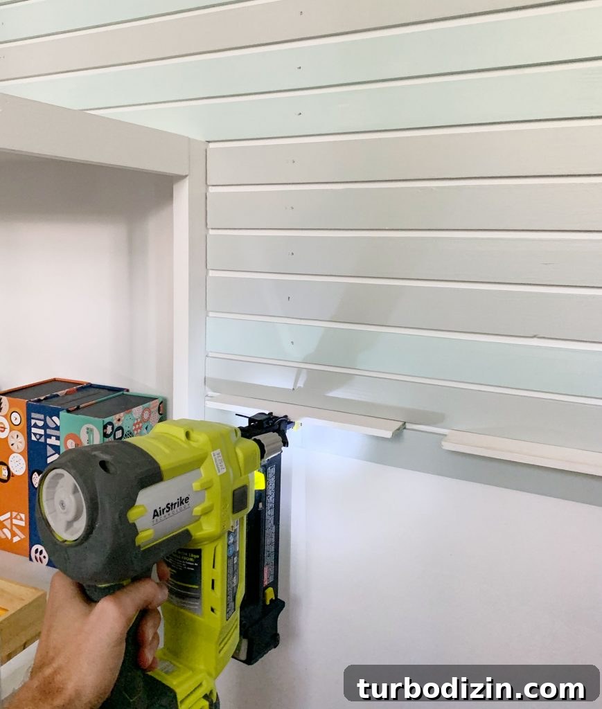 How to Create a Colorful Wood Accent Wall: DIY Guide 14 Nail Gun Attaching Smaller Lattice Pieces Onto Wall Next To Bookshelf