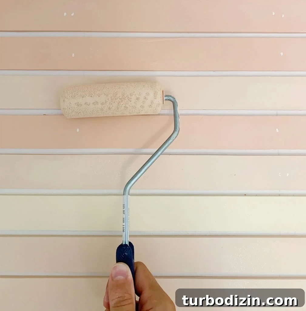 How to Create a Colorful Wood Accent Wall: DIY Guide 18 Small Foam Roller Doing Touch Up On Orange Painted Stripe