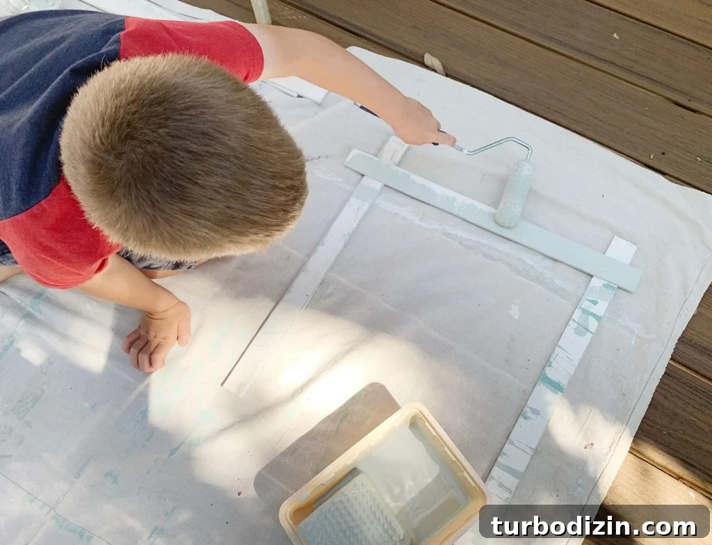 How to Create a Colorful Wood Accent Wall: DIY Guide 8 Young Boy Painting Wood Piece With Small Foam Roller