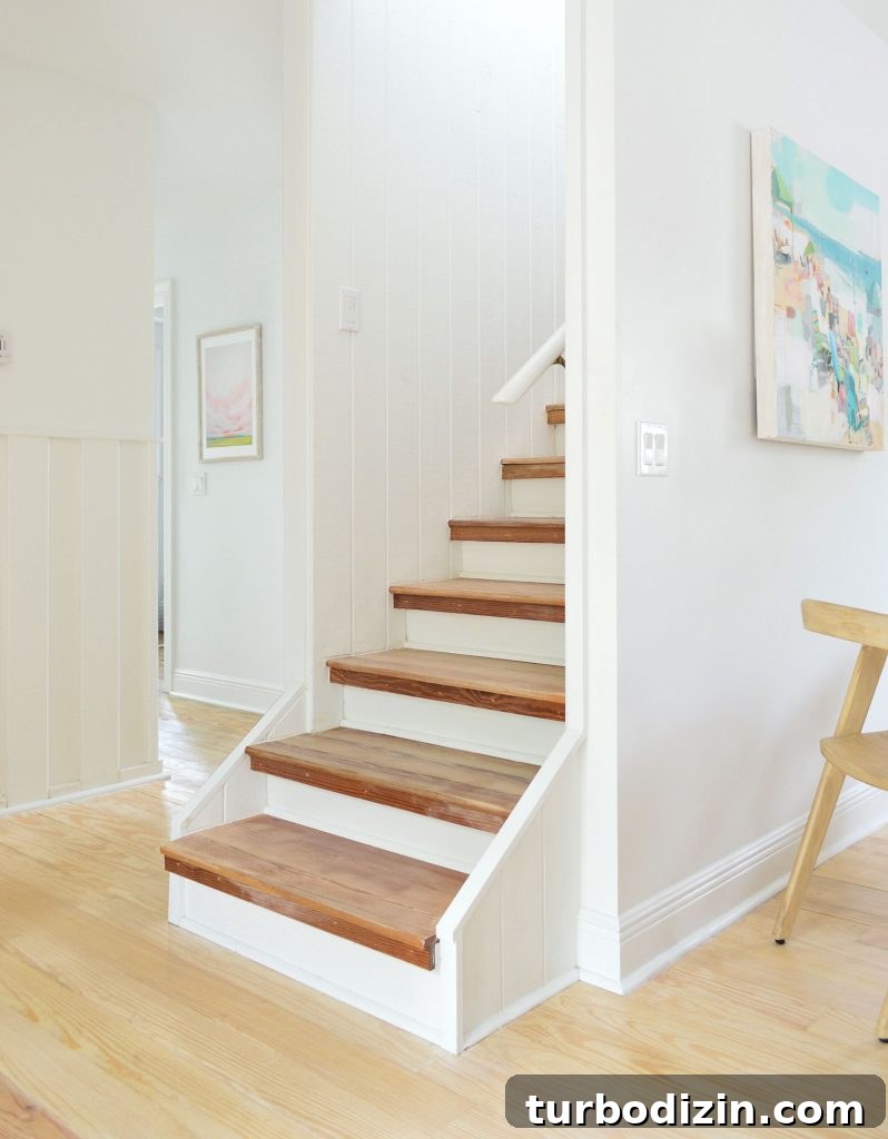 Bare wood stairs in white house