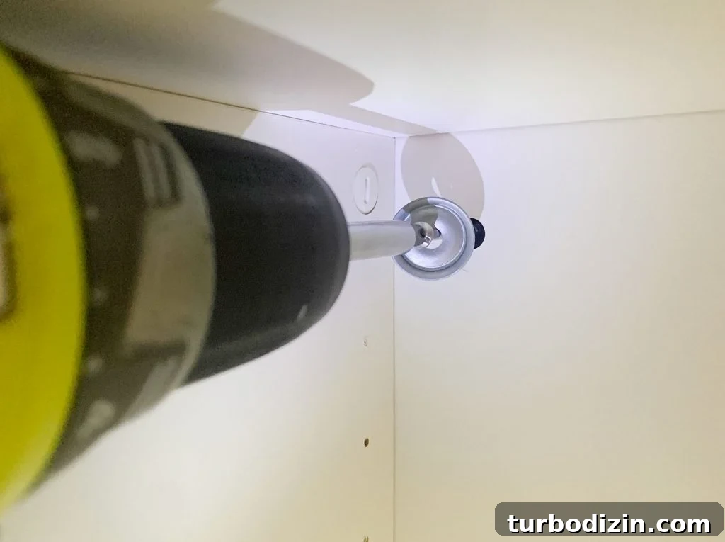 Screwdriver Installing Screw To Secure Ikea Besta Cabinet To Wall