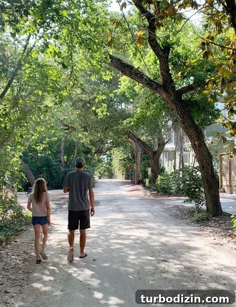 John and daughter walking in tree covered neighborhood