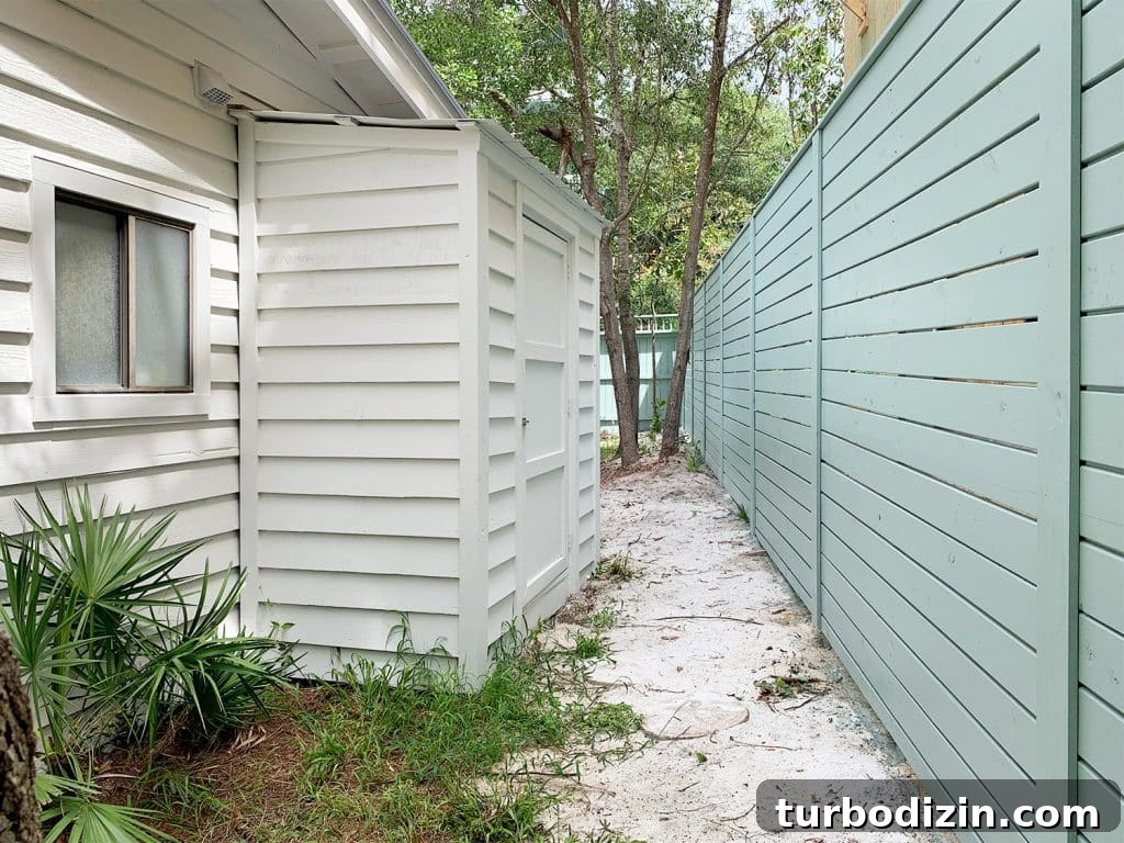 Small white shed attached to side of white house