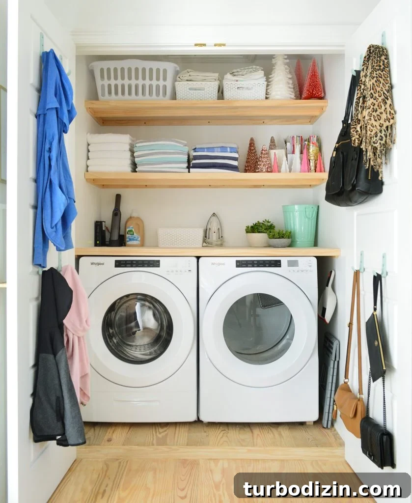 Front loading laundry appliances in closet with wood shelves on top