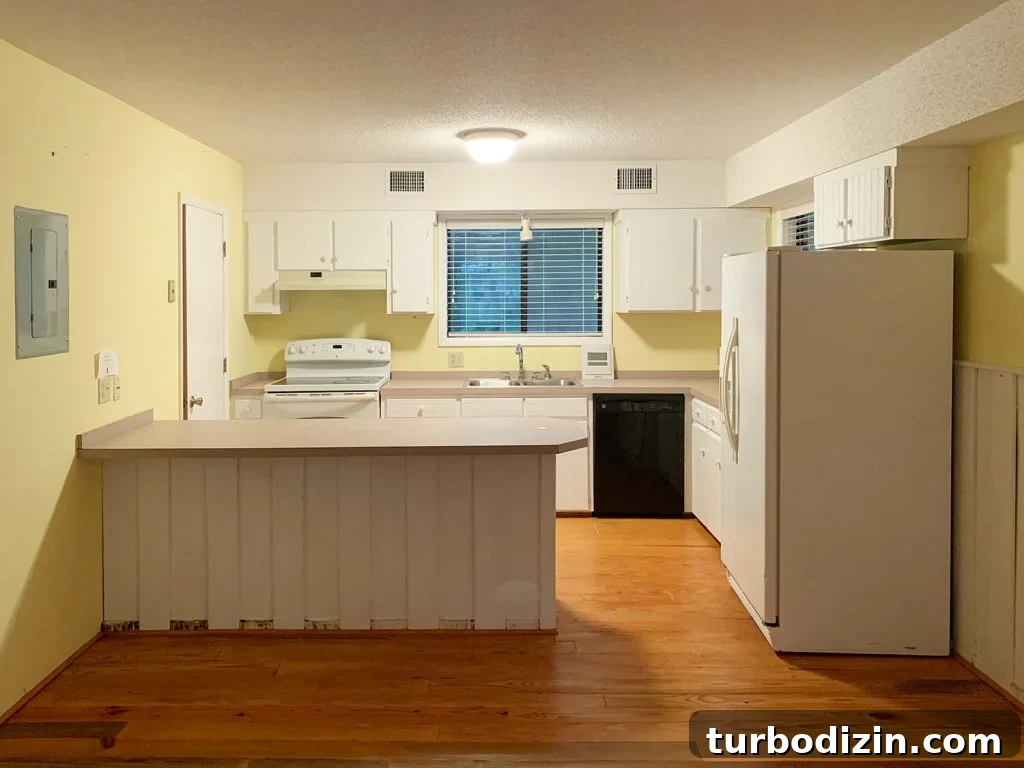 Our Kitchen and Sitting Area: Six Months of Living In 16 Before photo of kitchen with white cabinets and large peninsula