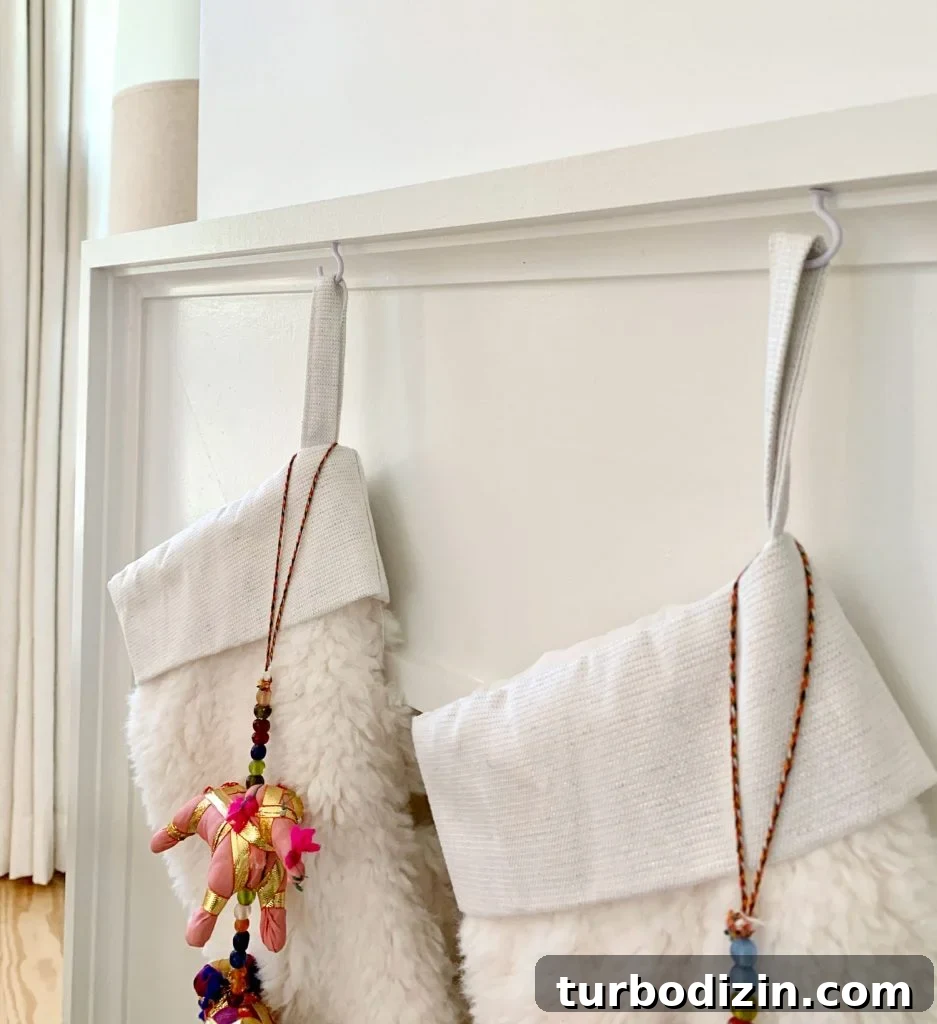 Modern Fireplace Mantel Ideas: Step-by-Step Build Guide 21 Close up detail of stockings hanging from mantel using small white cup hooks