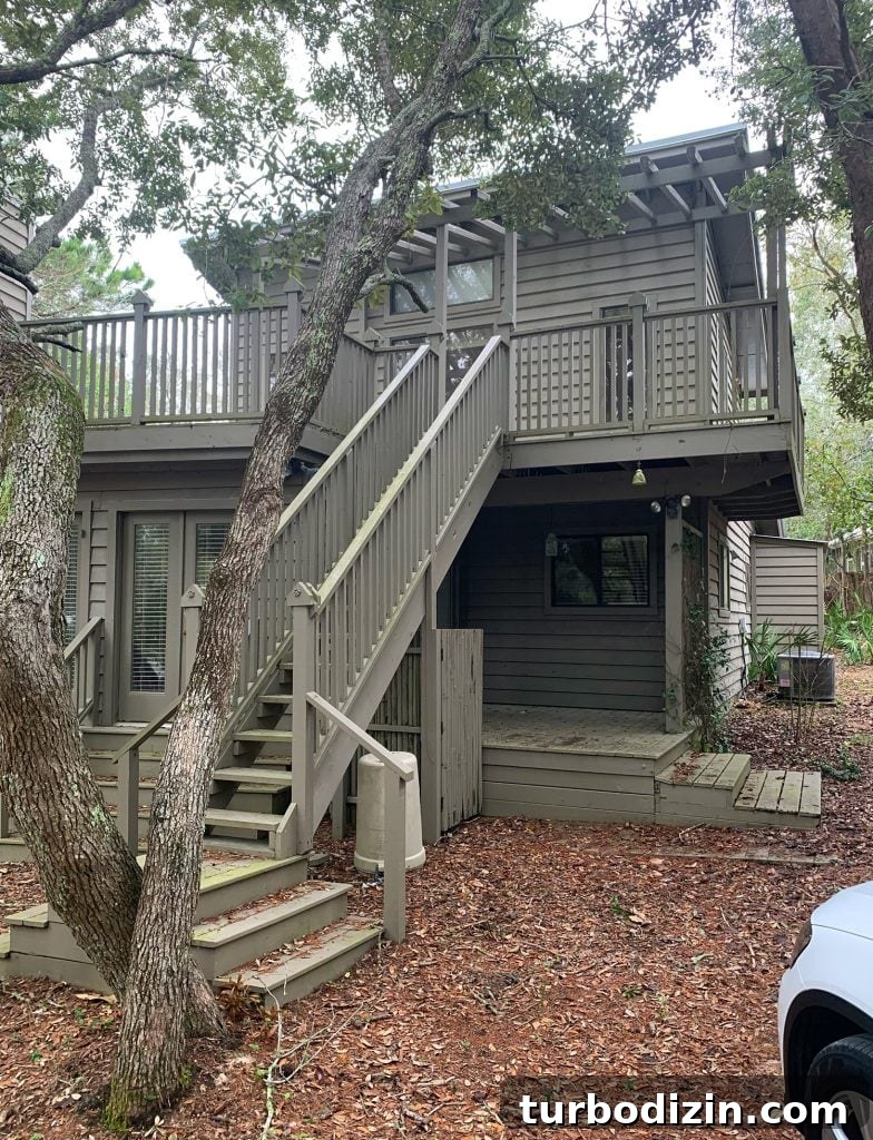 Before Photo of Side Of House With Staircase To Upstairs Porch And Painted Brown