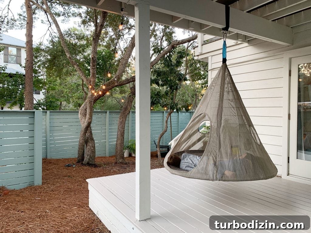 Two kids laying in hanging tent on covered porch