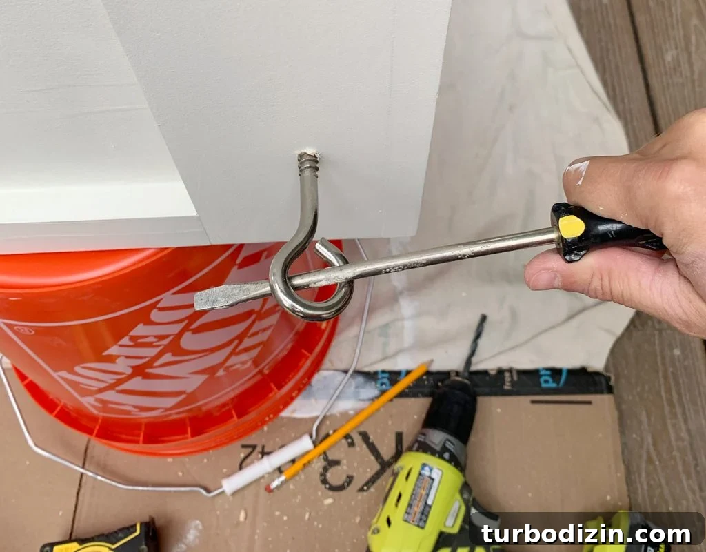 How to Hang an Outdoor Daybed: Step-by-Step Video Guide 7 Turning eyehook in hanging daybed using long screwdriver