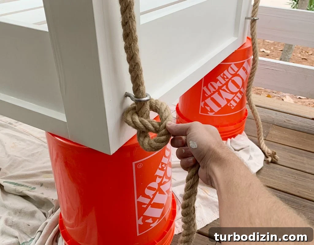 How to Hang an Outdoor Daybed: Step-by-Step Video Guide 8 Typing pretzel knot on the bottom of hanging daybed under eyehook