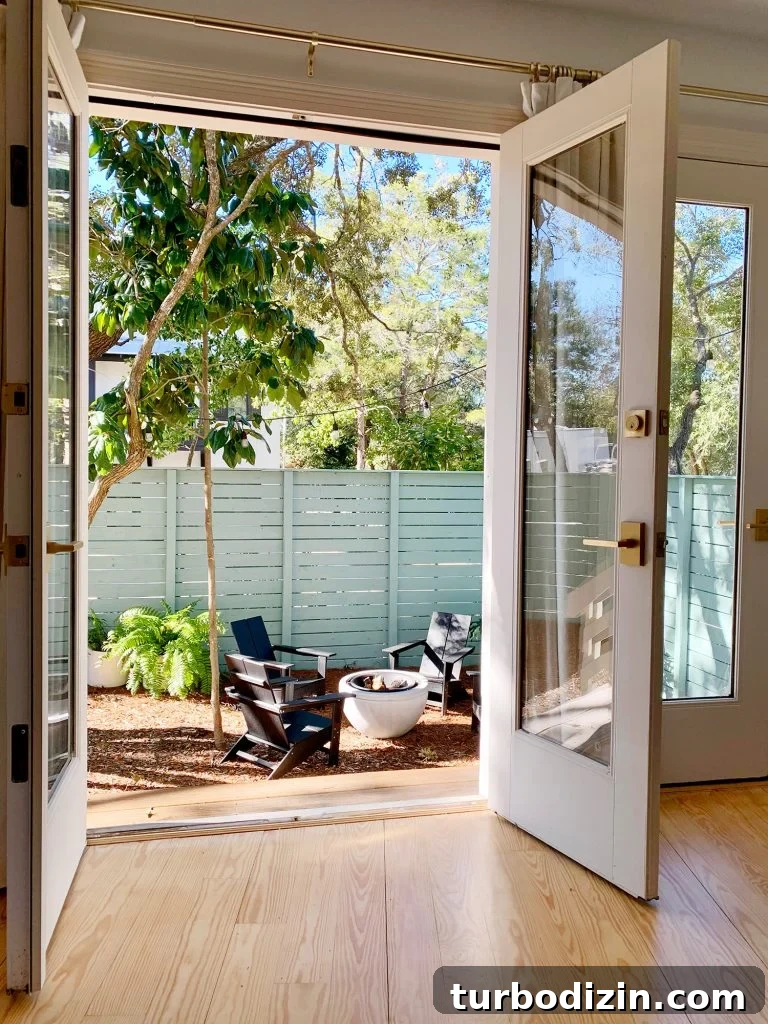 View of fire pit area through open french doors in bedroom