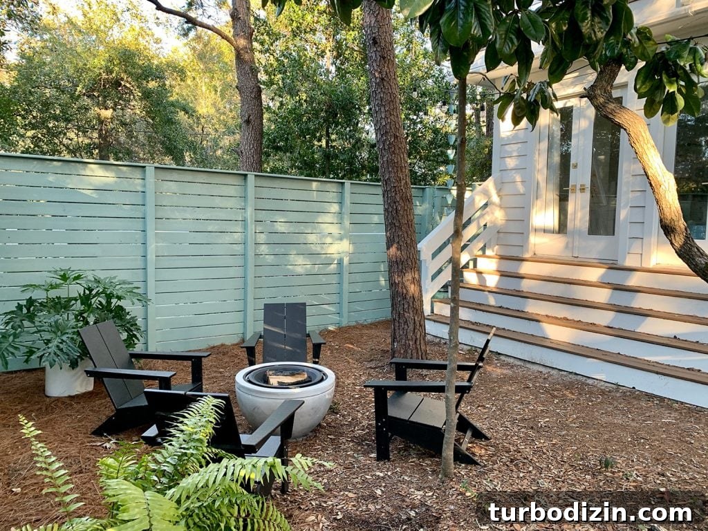 Before and After Home Photos: 14 Months of Renovation Progress 48 Firepit Area With Black Adirondack Chairs In Front Of Green Fence