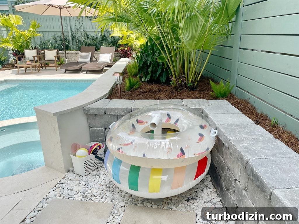 Pool floats organized on PVC pipe stand behind retaining wall