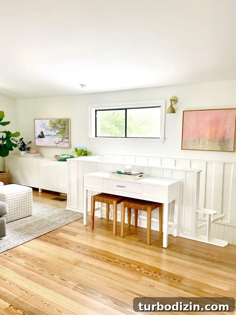 Family Room That Doubles as Office, Art Studio, and Home Theater 16 Console Table By Stairs In Upstairs Modern Family Room With White Paneled Wainscoting