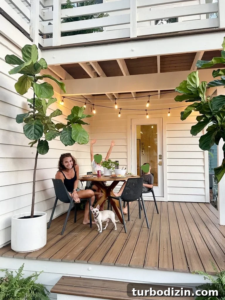 Transforming Our Kitchen Porch into a Cozy Dining Nook 7 Family eating outside on covered porch with string lights on and chihuahua under table